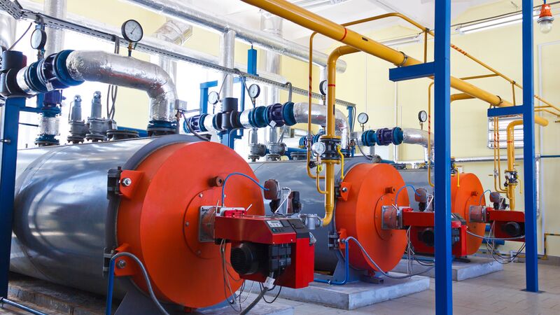 Industrial boiler system with insulated pipes and pressure gauges in a mechanical room